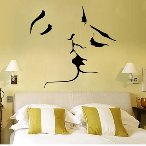 Minimalist black vinyl wall decal featuring an artistic couple kissing silhouette in bedroom