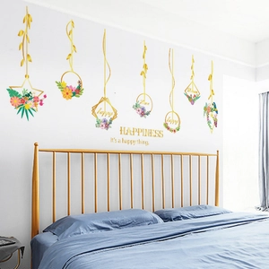 Detail view of Nordic gold flower wall stickers and happiness text above a metal bed frame