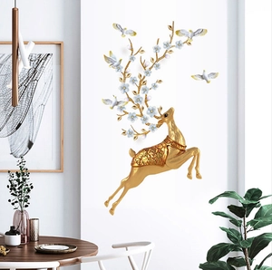 Detailed view of a golden jumping deer wall decor with blue floral antlers and white doves