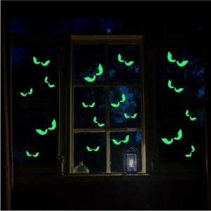 Glow in the dark Halloween bat and eye stickers on window with fluorescent green light effect