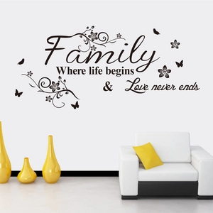 Family quote wall decal with black floral vine and butterflies over a modern sofa