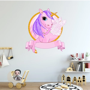 Pink cartoon unicorn wall decal with golden frame in a cozy kids room setting