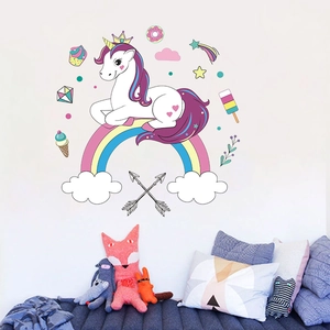 Detailed view of cartoon unicorn and rainbow wall decals in a cozy nursery room setting