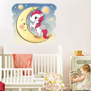 Détail d'un sticker mural licorne sur la lune dans une chambre d'enfant douillette