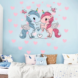 Detail view of pink and blue unicorn wall decals with heart stickers in a nursery setup