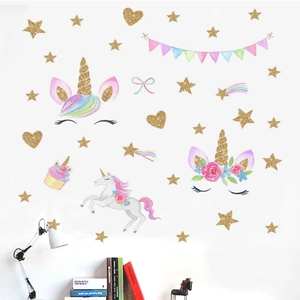 Détail de stickers licorne dorés peints à la main avec étoiles dans une chambre chaleureuse