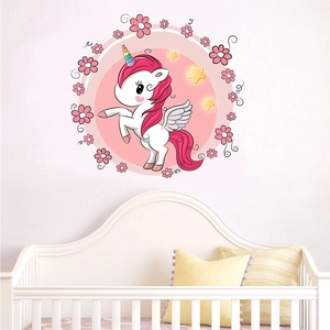 Pink cartoon unicorn wall decal detail shown in a cozy white nursery room setting