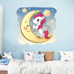 Close-up of pink unicorn wall decal sitting on a yellow moon in a cozy kid's bedroom