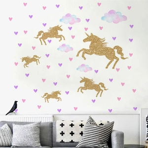 Détail de stickers licorne dorée scintillante et nuages roses dans une chambre d'enfant