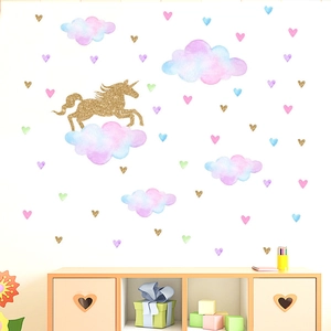 Détail de stickers licorne dorée pailletée et nuages aquarelle dans une chambre enfant