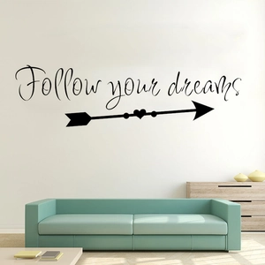 Detail view of Follow Your Dreams black wall decal with heart arrow in a modern living room
