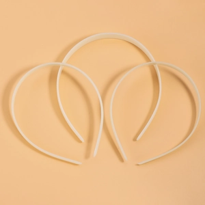 Three pieces of white translucent ABS plastic headbands on a warm orange background