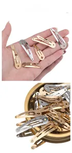Macro shot of silver and gold metal snap clips piled in a round tray and palm