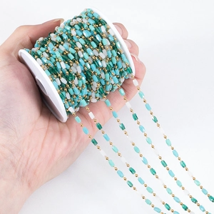 DIY bunte facettierte Perlenkette mit vergoldeten Gliedern auf einer weißen Spule