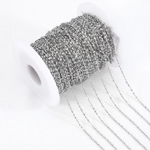 Dunne zilveren roestvrijstalen platte kabelketting voor DIY-sieraden op een witte spoel