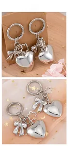 Detail of silver heart charm with bow and flower pendant on star tulle background