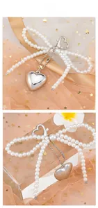 Detail of silver heart pendant with large pearl bow chain and heart lobster clasp