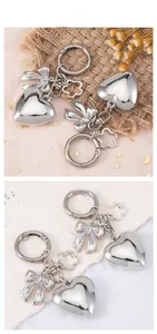 Detailed view of silver heart pendant with ribbon bow and flower charms on a rustic background