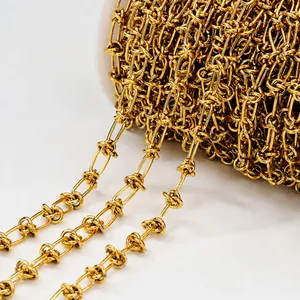 Macro shot of gold-plated twisted knot chain on white spool for DIY jewelry making
