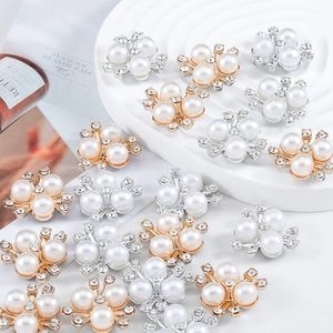 Detailed macro of crystal rhinestone pearl flower charms for DIY jewelry and apparel crafting