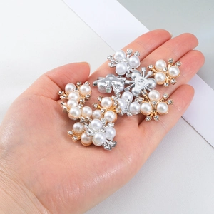 Macro view of snowflake-shaped alloy accessories with pearls and rhinestones on a hand