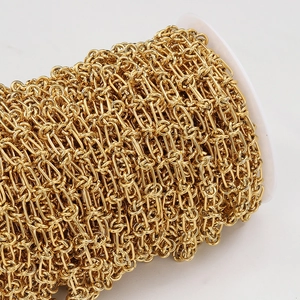 Macro shot of gold double-ring cable chain on white spool for DIY jewelry making