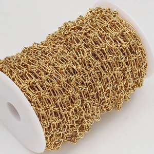 Macro detail of high-quality golden stainless steel chain on a white plastic spool
