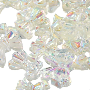 Iridescent aurora resin bow nail art charms with holographic finish on white background