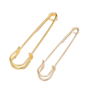 Minimalist gold and silver safety pin brooches for waist adjustment on a white background