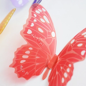 Macro shot of 3D orange butterfly wall sticker with silver glitter and double wings