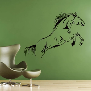 Detail view of black jumping horse wall sticker on a dark green living room wall background