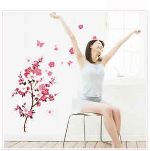 Pink plum blossom PVC wall decals with butterflies displayed on white striped wall