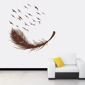 Modern wall sticker featuring brown feathers and flying birds above a stylish sofa