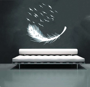 Modern wall sticker featuring white feathers and flying birds on a dark grey bedroom wall