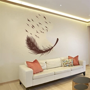Modern wall sticker featuring brown feather and flying birds above a cozy white sofa