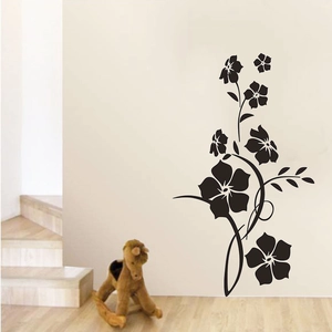 Detail of elegant black floral vine wall sticker applied on a cozy bedroom wall