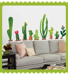 Cactus watercolor wall stickers for living room decor above a grey fabric sofa