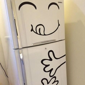 Close-up of a funny smiling face fridge sticker with tongue out and open hands