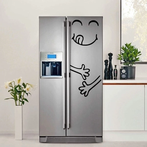 Funny black smiley face stickers with open hands on a modern stainless steel fridge