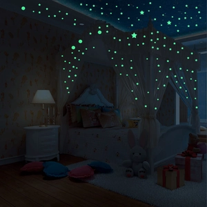 Luminous star and dot wall stickers glowing in bright green on a bedroom ceiling