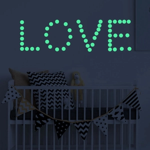 Luminous star and dot wall stickers forming a glowing LOVE text in a dark kids room