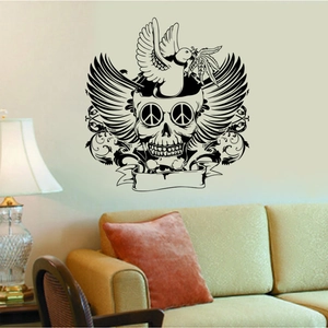 Détail d'un sticker mural noir avec crâne et ailes décorant un mur au-dessus d'un canapé