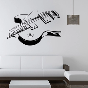 Close-up of minimalist black guitar wall decal in a modern living room setting