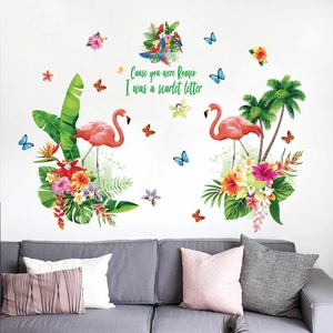 Tropical flamingo wall decals with palm leaves and parrots over a grey sofa on white wall