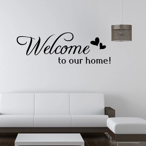 Detail of minimalist Welcome to our home wall sticker above a white modern sofa in the living room