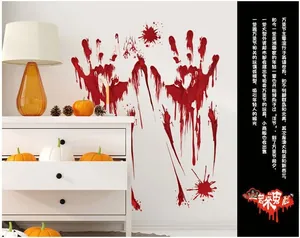 Detail view of Halloween red bloody handprint wall stickers on a white cabinet with pumpkins