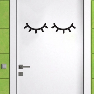 Minimalist black eyelashes wall decal stickers for home decor on a white wooden door