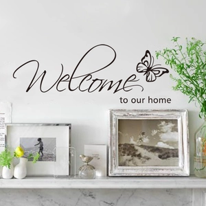 Welcome to Our Home wall sticker with butterfly graphic on a minimalist white wall