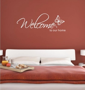 Elegant white Welcome To Our Home wall sticker with butterfly decor on a bedroom wall