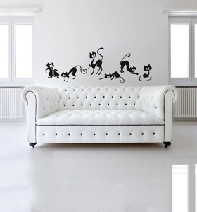 Stickers muraux chats noirs minimalistes avec six motifs de chats au-dessus d'un canapé